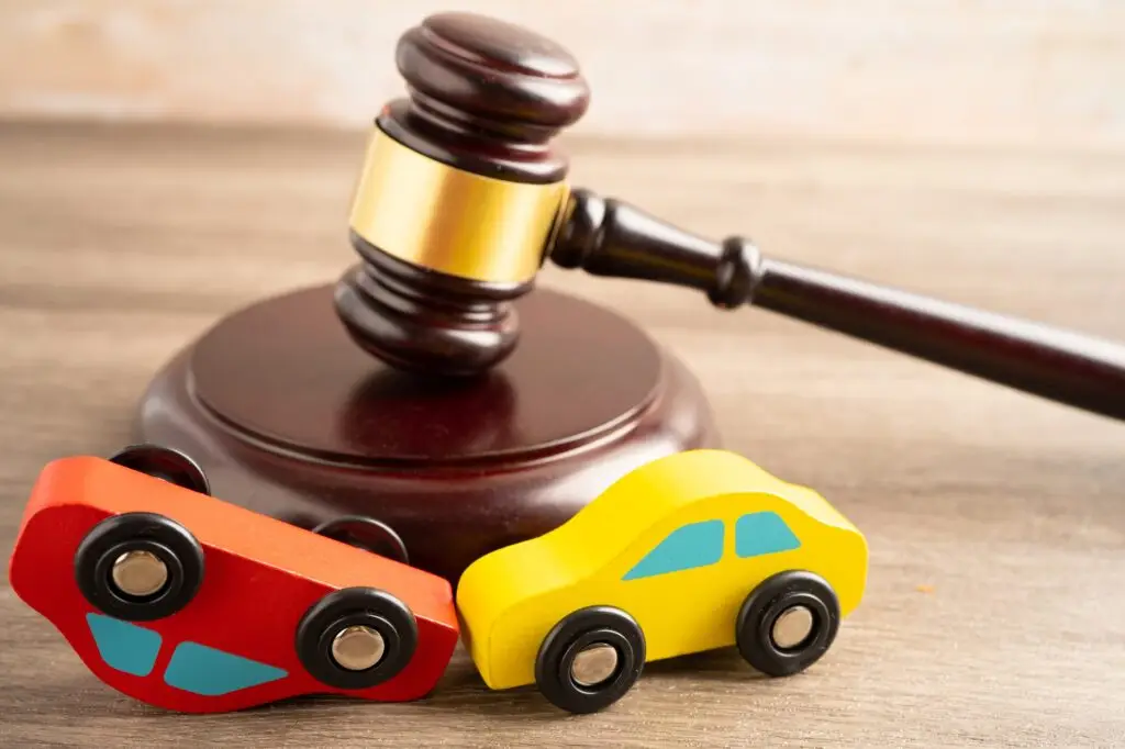 Hammer gavel judge with car vehicle accident, insurance coverage claim lawsuit court case.